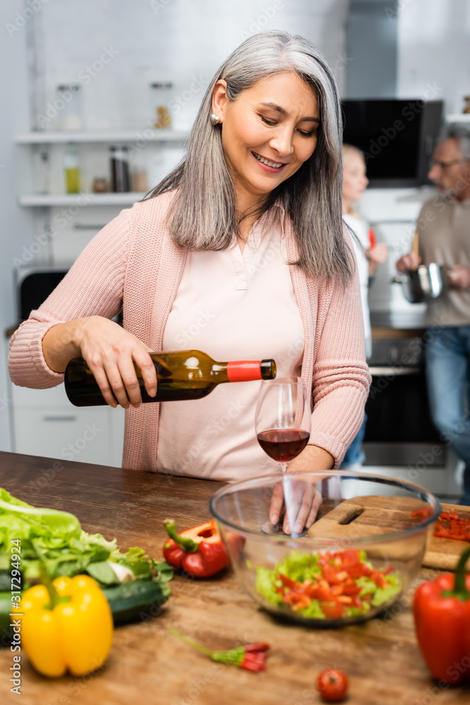selective focus of smiling asian woman pouring wine to glass selective focus of smiling asian woman pouring wine to glass