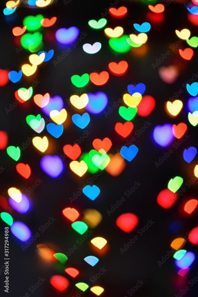 Heart. Abstract bokeh lights in colorful little heart shape on black background. Christmas  and valentines day. Blurred  vertical background.