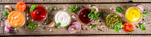 Принти на полотні Set of sauces in small bowls - ketchup, mayonnaise, mustard, bbq sauce, pesto, classic burger sauce, with spices and herbs in