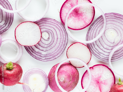 A macro view of an arrangement of overlapping red onion rings and daikon, radish and red onion slices. photo