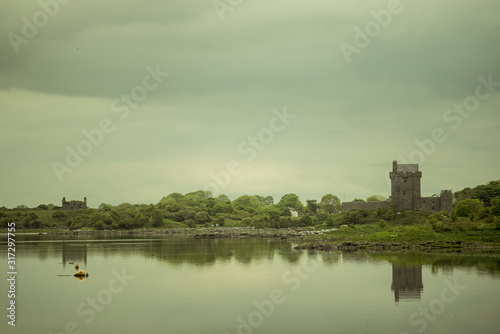 View of the Dunguaire Castle, Galway Bay in Kinvara, Ireland. Beautiful landscape with with the bay and the Atlantic Ocean and a green forest. Reflections on the water.