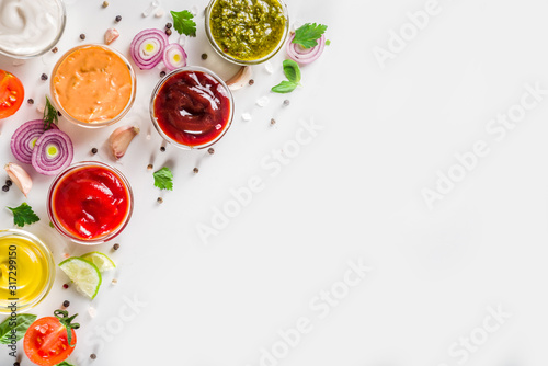 Картината върху платно Set of sauces in small bowls - ketchup, mayonnaise, mustard, bbq sauce, pesto, classic burger sauce, with spices and herbs in