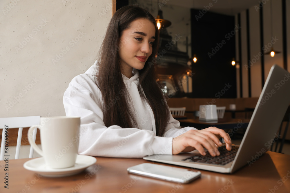 Young blogger working with laptop in cafe Young blogger working with laptop in cafe