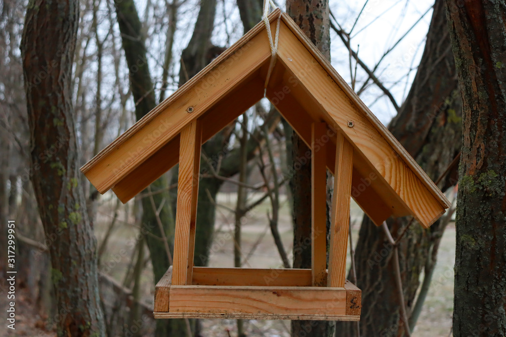 Wooden bird feeder on a tree. A house for birds made by man. Wooden bird feeder on a tree. A house for birds made by man.