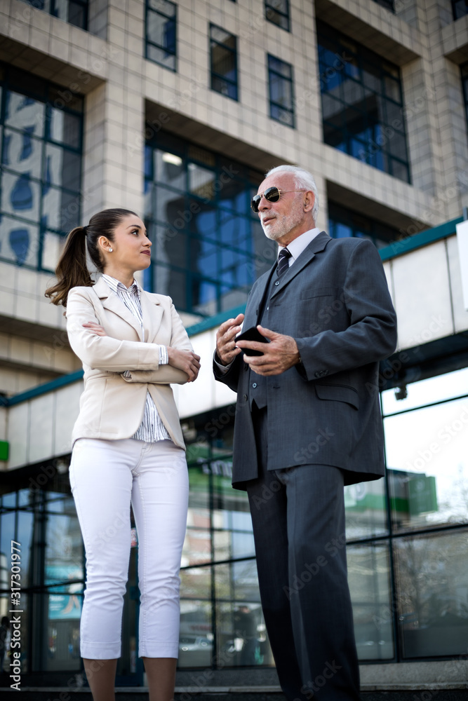 An older man and a young colleague are talking about work An older man and a young colleague are talking about work
