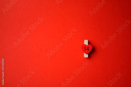 St. Valentine's Day. Wooden clothespin with a heart on a red background.