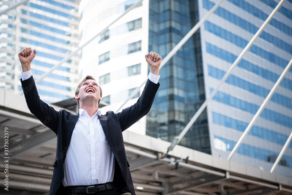 Portrait images of Cauacsian, businessmen With both hands raised above the head, Happy gesture From successful businesses with blur tail building background. Portrait images of Cauacsian, businessmen With both hands raised above the head, Happy gesture From successful businesses with blur tail building background.