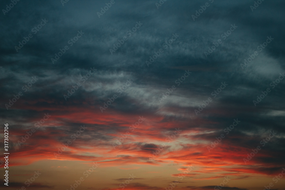 Obraz premium Sky at sunset, gray red clouds closeup background texture