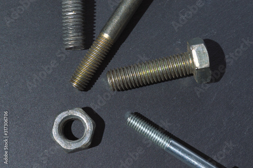 old bolts and nuts on a dark background. Top view.