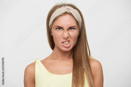 Photo Close-up of displeased young pretty blonde lady with casual hairstyle twisting h