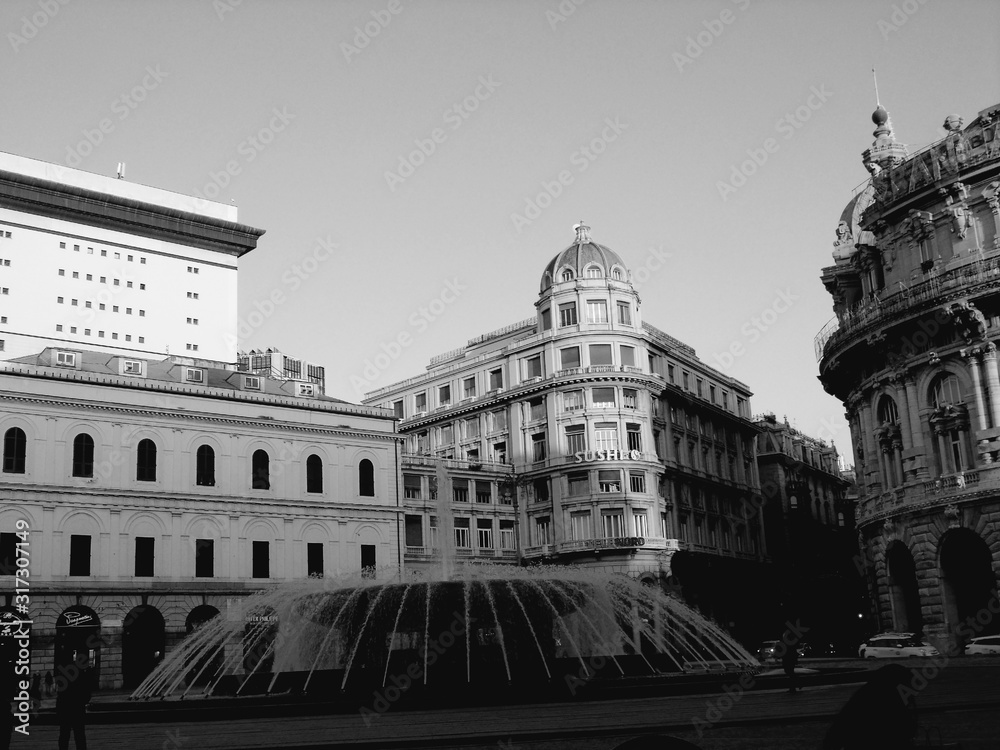 Genova, Italy - 01/22/2020:  Panoramic view to the city center of Genoa in winter beautiful day. Amazing view to the old architecture with blue sky in the background and the moon over the city.