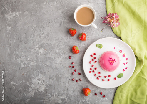 Pink mousse cake with strawberry  and a cup of coffee on a gray concrete background. top view, copy space.
