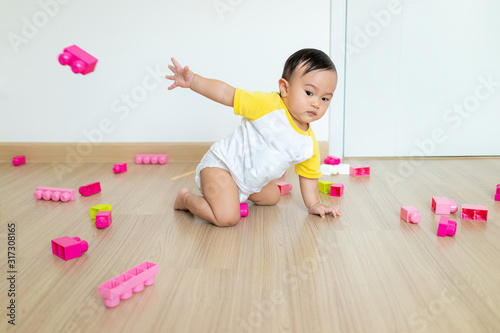 Cute baby boy learning different skills like throwing catching things.