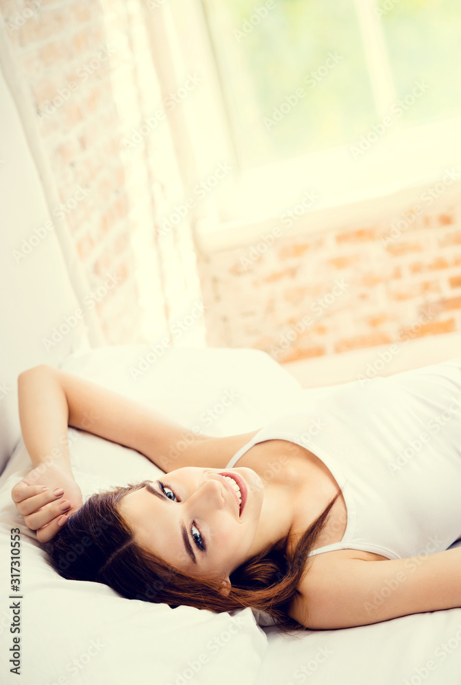 Obraz premium Portrait of beautiful happy smiling lovely girl waking up at bedroom