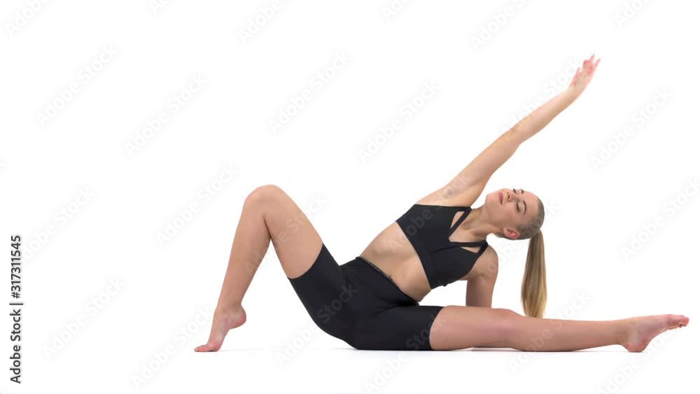 Woman having training. Fit girl stretching her body by performing side inclines during the training. Isolated, on white background. Fitness, yoga and healthy lifestyle concept Woman having training. Fit girl stretching her body by performing side inclines during the training. Isolated, on white background. Fitness, yoga and healthy lifestyle concept