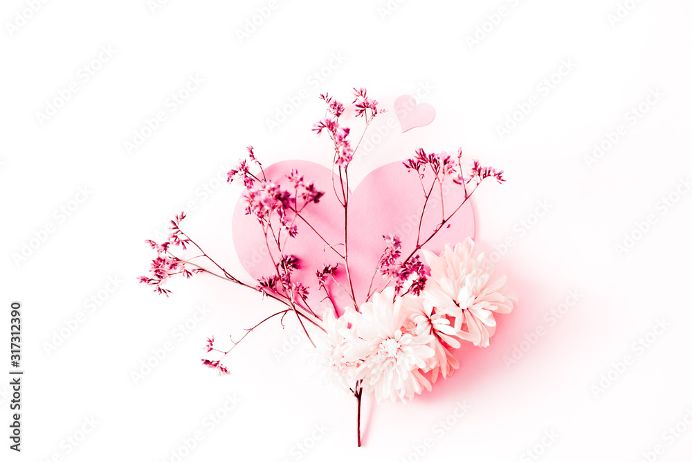 A large pink heart decorated with small pink flowers branch and some chrysanthemum on a pink tint background A large pink heart decorated with small pink flowers branch and some chrysanthemum on a pink tint background