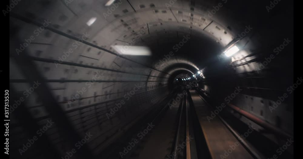View through the glass of subway car riding at high speed in the underground. City high-speed and convenient transport for commuting. Fast underground train riding in tunnel of modern city.