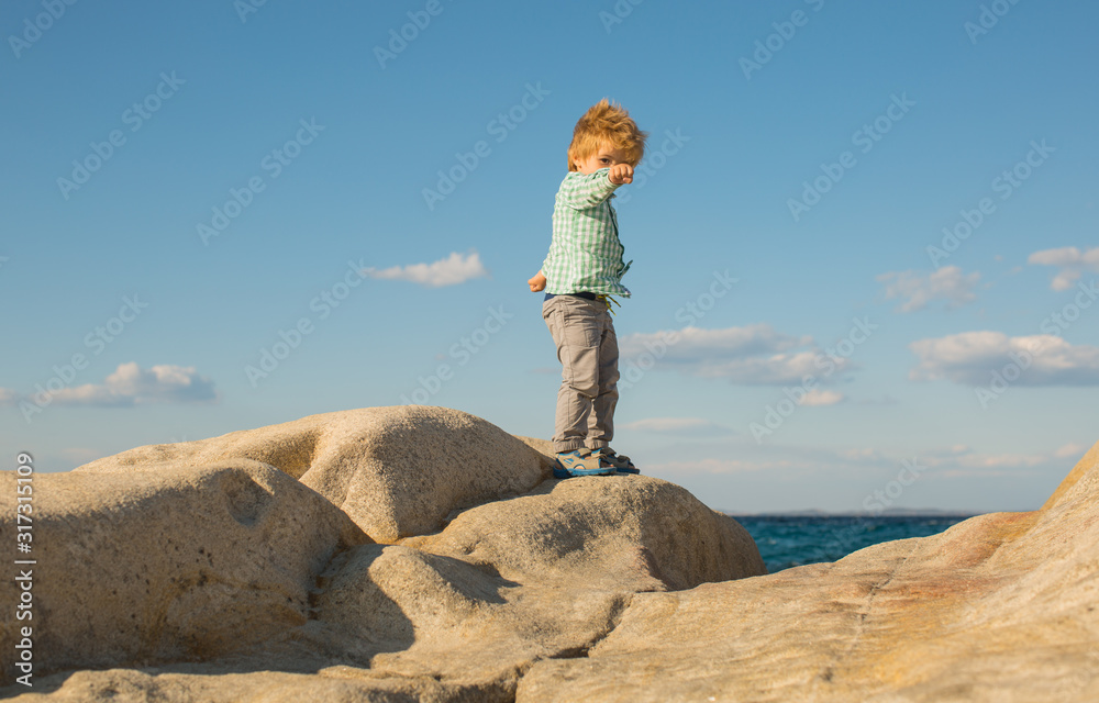 Martial arts. Exercise in nature. A child does yoga asanas near the sea.