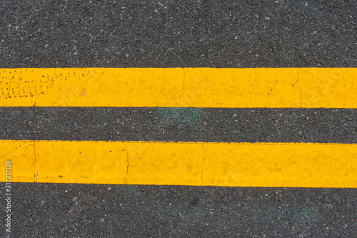 Double yellow lines on city street. © Noel