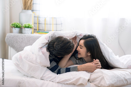 Love and happiness concept, Asian man and woman having fun in bedroom.