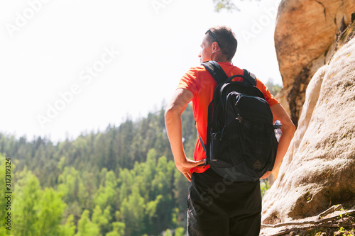 Hiker with backpack standing on top of a mountain. Active healthy lifestyle adventure journey vacations.
