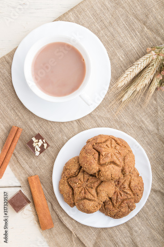 homemade oatmeal cookies with a cup of cocoa on a white wooden background. top view, close up.