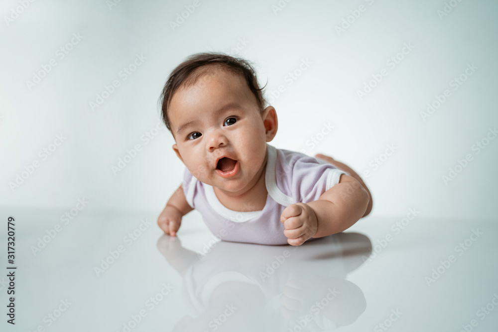 baby laying on her belly. tummy time cute baby in studio portrait on white background baby laying on her belly. tummy time cute baby in studio portrait on white background