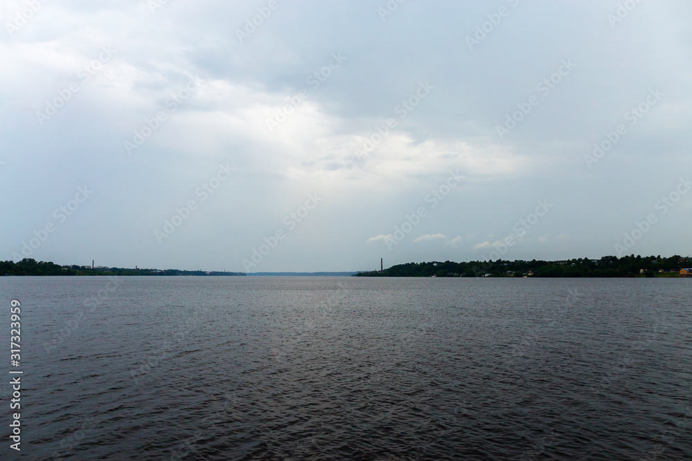 Rain over the Volga. View of a pine forest located on the river Bank. Ivanovo region, Russia.