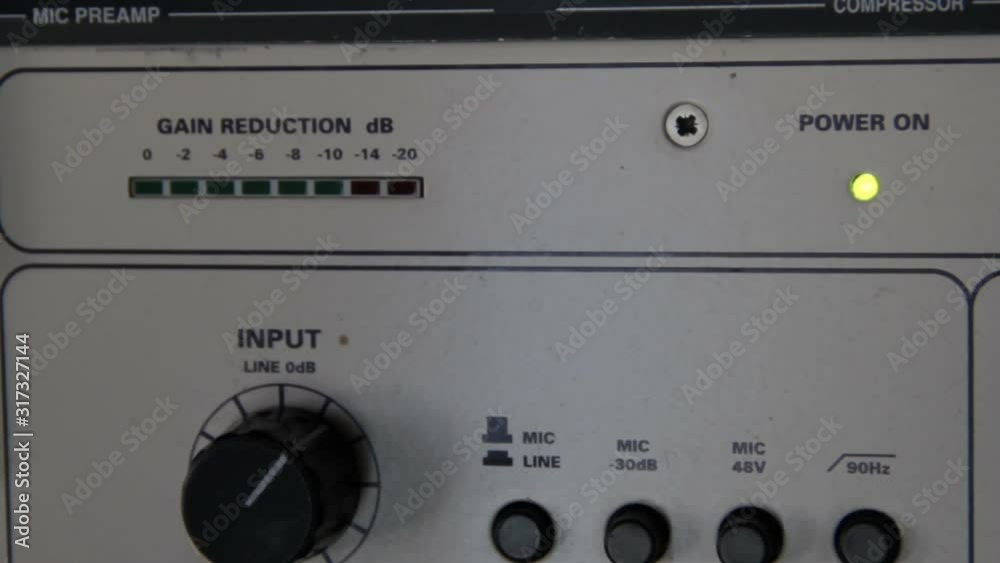 A rack of audio compressors and other components of sound reinforcement system in a recording studio close up. Signal and sound level indicators,input knob macro.Making music in a professional studio A rack of audio compressors and other components of sound reinforcement system in a recording studio close up. Signal and sound level indicators,input knob macro.Making music in a professional studio