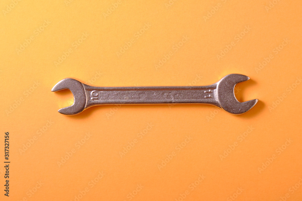 Chrome wrench on a yellow background, top view Chrome wrench on a yellow background, top view