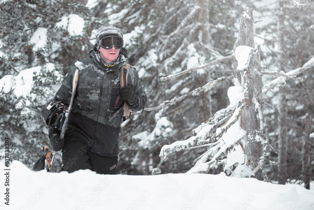 Snowboarder with snowboard in the winter forest in the mountains. Snowboarder with snowboard in the winter forest in the mountains.
