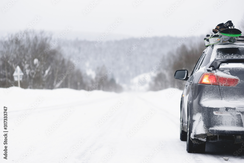 Snowboards on the roof of the car. Ski resort background.