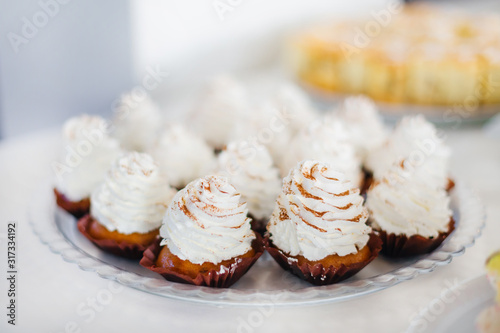 cupcakes covered with white cream on a plate. wedding banquet.