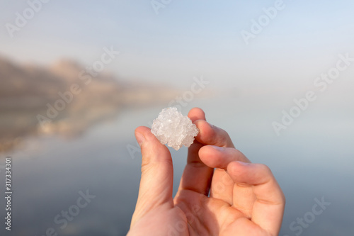 Male hand holding the salt crystal from the Dead Sea in Israel