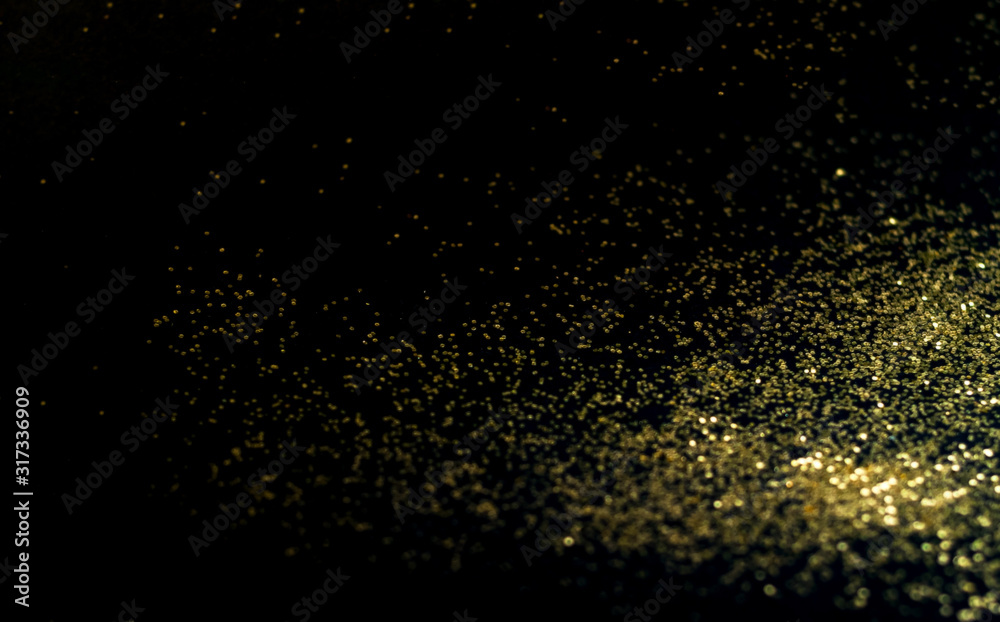 Black background with golden sparkles. Blurred effect. Concept for festive background or for project.Copy space