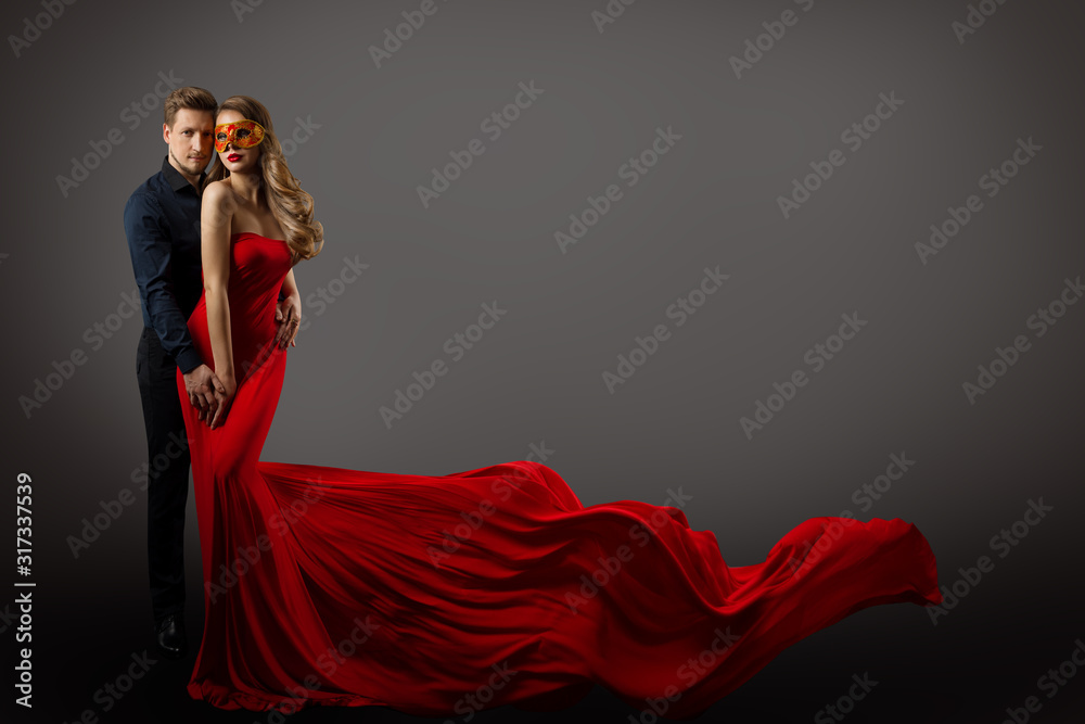 Fototapeta Couple Beauty Portrait, Beautiful Woman in Mask and Red Dress and Elegant Man, Gown Fluttering on wind