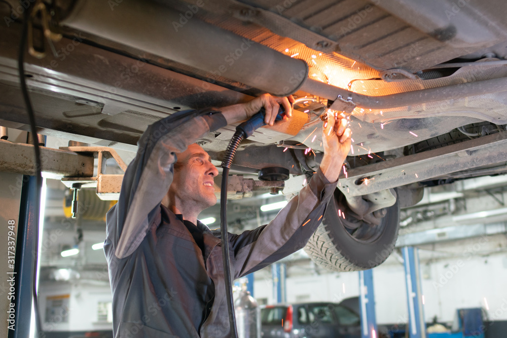 A man without a mask uses a welding machine, a safety violation A man without a mask uses a welding machine, a safety violation