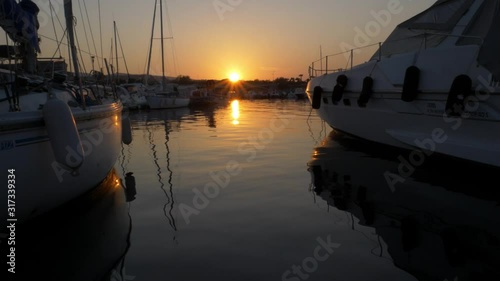 Sonnenuntergang mit Spiegelung im Meer im Hafen zwischen Booten und Segelbooten in Frankreich, Südfrankreich