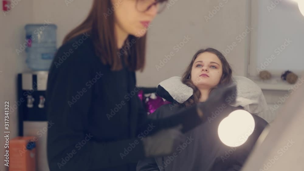 Professional woman eyebrow master cleans eyebrows to client in beauty salon. Professional woman eyebrow master cleans eyebrows to client in beauty salon.