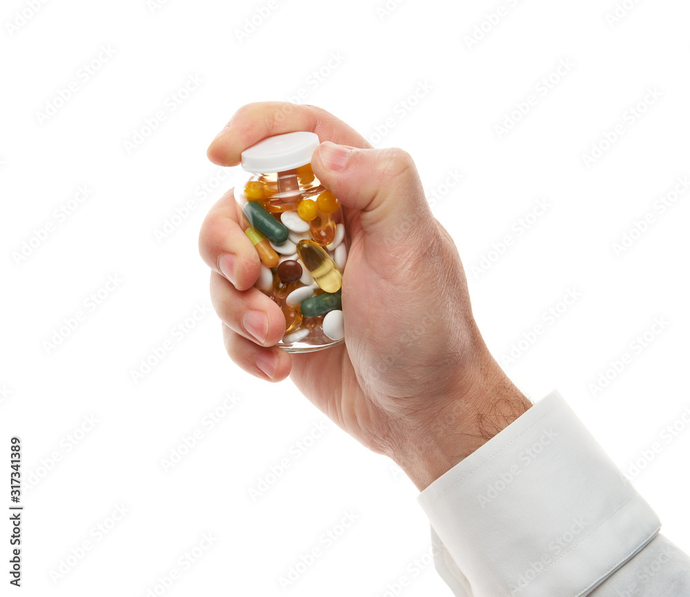 Man hand opening glass bottle full of pills, tablets, vitamins, drugs, capsules isolated on white background. White shirt, business style. Health care concept. Pharmaceutical industry. Pharmacy. Man hand opening glass bottle full of pills, tablets, vitamins, drugs, capsules isolated on white background. White shirt, business style. Health care concept. Pharmaceutical industry. Pharmacy.
