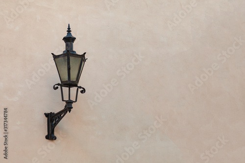 Antique street lamp attached to the wall of the house
