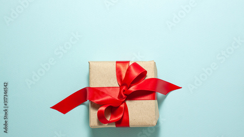 Banner of brown paper gift box with a red satin ribbon bow flat lay