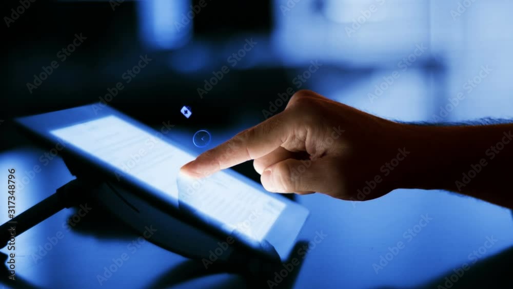 Man using a digital tablet with holographic app icons flying from it. Futuristic technology. Blue. Locked. Office background. More color options in my portfolio.
