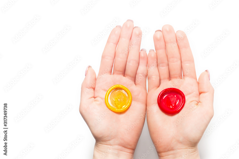 color condom in female hand isolated on a white background