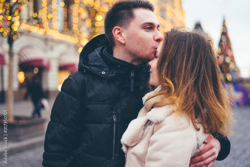 Loving couple on the street on christmas background.
