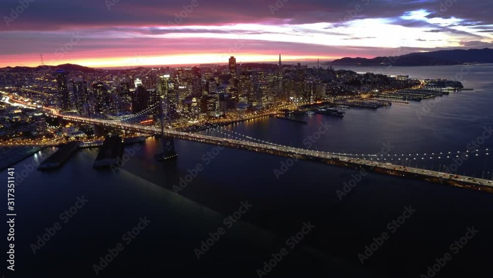 Aerial view of the Bay Bridge and San francisco financial district at sunset. California. United States. Night. Shot from helicopter. Aerial view of the Bay Bridge and San francisco financial district at sunset. California. United States. Night. Shot from helicopter.