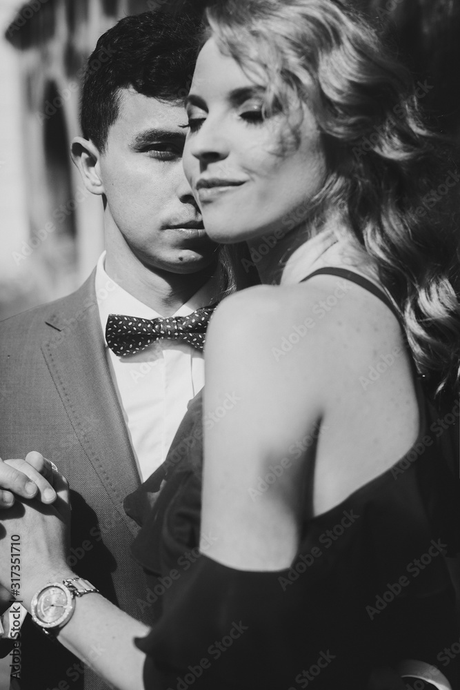 Φωτογραφία Stylish couple embracing in sunny light in european city street