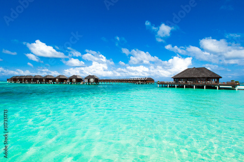 Beach with white sand  turquoise ocean water and blue sky with clouds in sunny day. Natural background for summer vacation. Panoramic view.