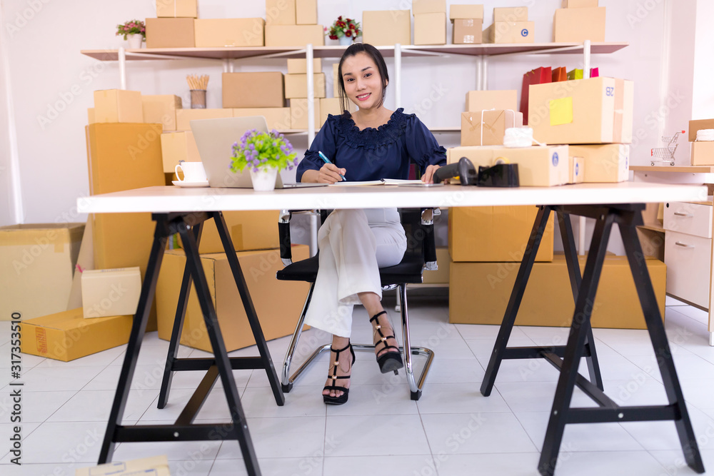 Asian women who are online shopping operators SME smiled confidently and looked at the camera, SME online shopping entrepreneurs or freelance concept Asian women who are online shopping operators SME smiled confidently and looked at the camera, SME online shopping entrepreneurs or freelance concept