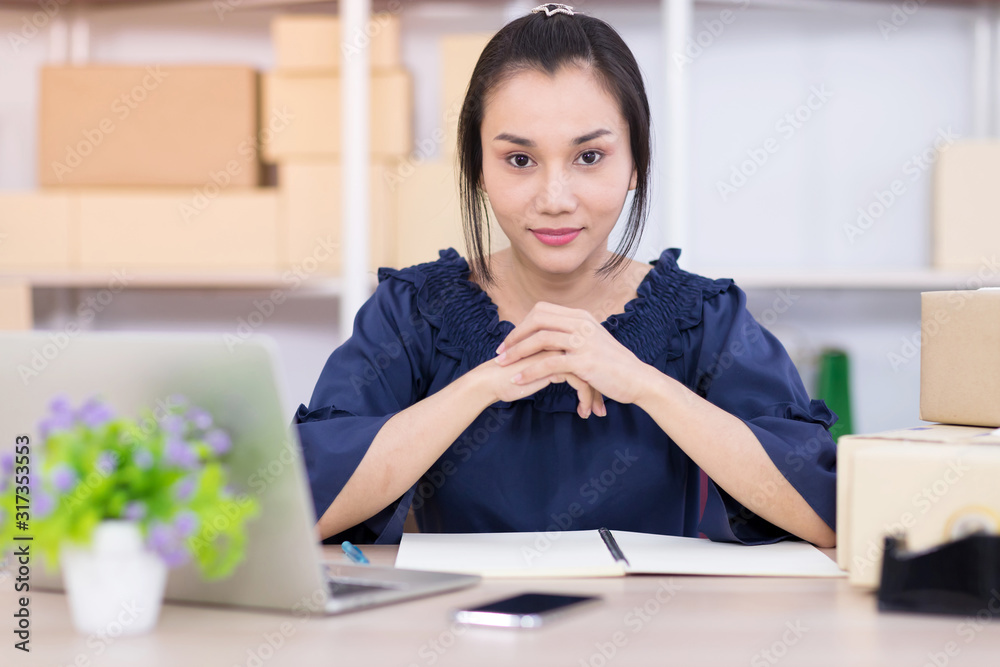 Asian women who are online shopping operators SME smiled confidently and looked at the camera, SME online shopping entrepreneurs or freelance concept Asian women who are online shopping operators SME smiled confidently and looked at the camera, SME online shopping entrepreneurs or freelance concept